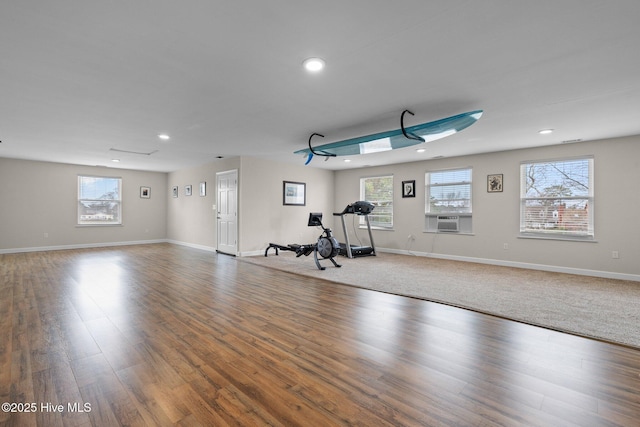 exercise room with cooling unit, plenty of natural light, and wood finished floors