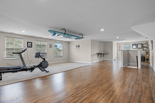 workout room featuring recessed lighting, a wealth of natural light, and wood finished floors