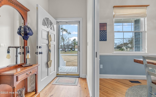 entryway with visible vents, baseboards, and wood finished floors