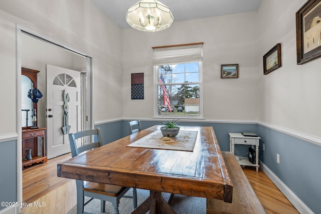 dining room with a notable chandelier, wood finished floors, and baseboards