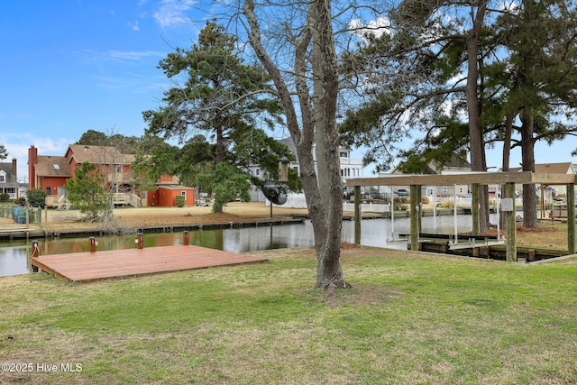 view of dock featuring a yard, a water view, and a residential view