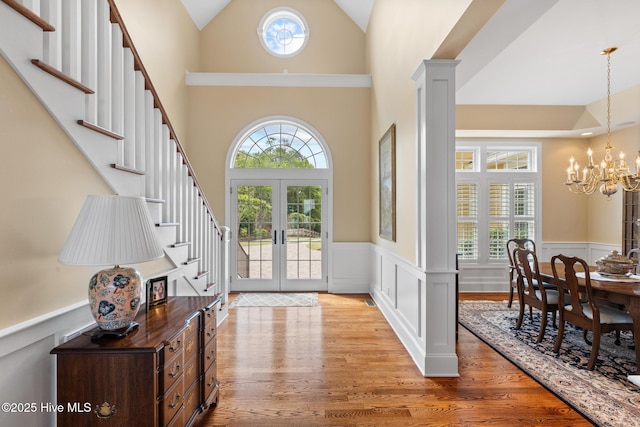 8904 Sound View Ct, Emerald Isle, NC 28594 - foyer with stairway, light wood finished floors, a wainscoted wall, a chandelier, and high vaulted ceiling
