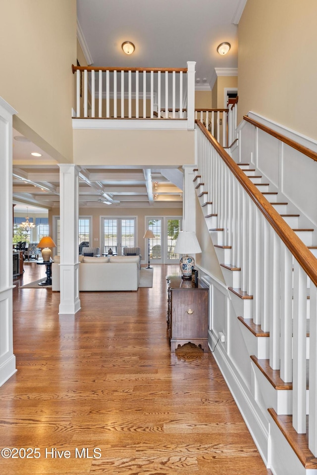 8904 Sound View Ct, Emerald Isle, NC 28594 - stairs featuring beamed ceiling, decorative columns, wood finished floors, and ornamental molding