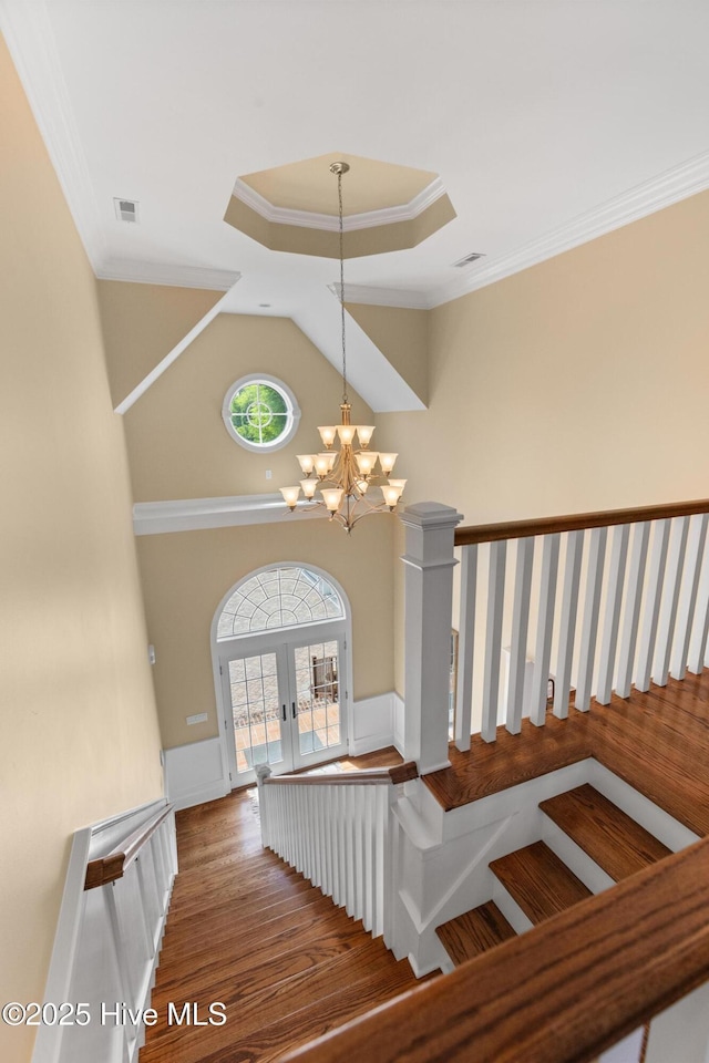 8904 Sound View Ct, Emerald Isle, NC 28594 - stairway with crown molding, wood finished floors, french doors, a notable chandelier, and visible vents