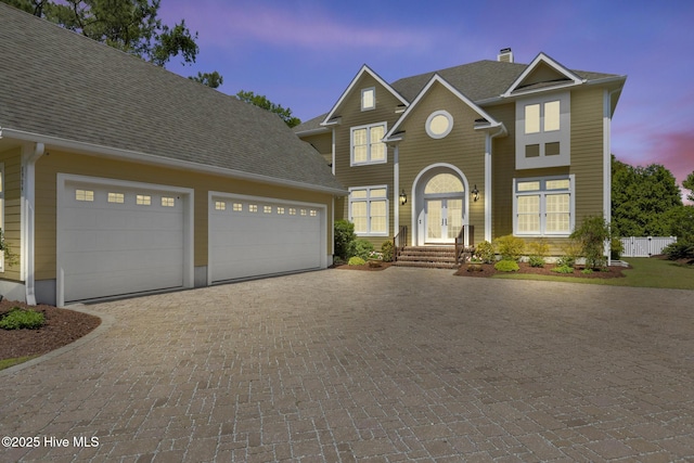 8904 Sound View Ct, Emerald Isle, NC 28594 - view of front facade with a chimney, a shingled roof, french doors, decorative driveway, and a garage