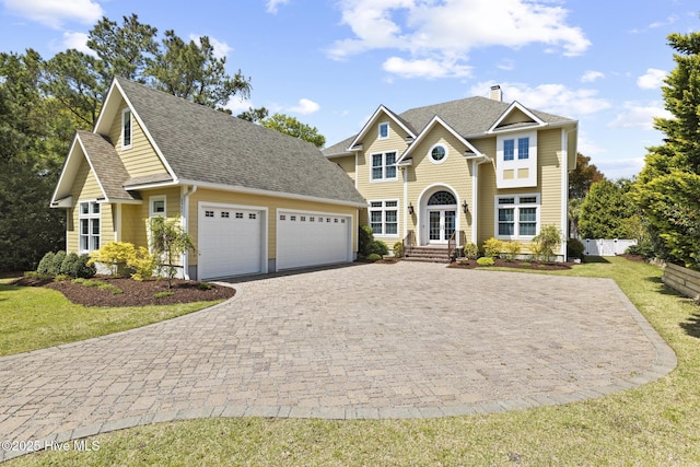 8904 Sound View Ct, Emerald Isle, NC 28594 - traditional-style house featuring french doors, roof with shingles, a garage, a front yard, and decorative driveway