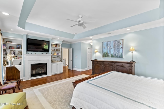 8904 Sound View Ct, Emerald Isle, NC 28594 - bedroom featuring a premium fireplace, wood finished floors, a raised ceiling, baseboards, and recessed lighting