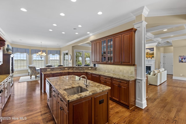 8904 Sound View Ct, Emerald Isle, NC 28594 - kitchen with dark wood finished floors, ornamental molding, a sink, a peninsula, and glass insert cabinets