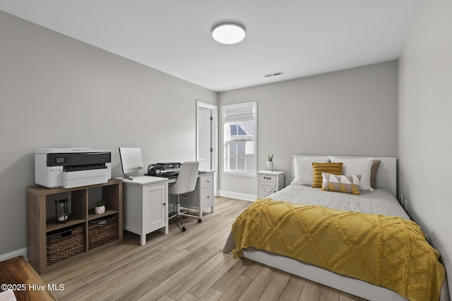 bedroom featuring visible vents, baseboards, and light wood-style flooring