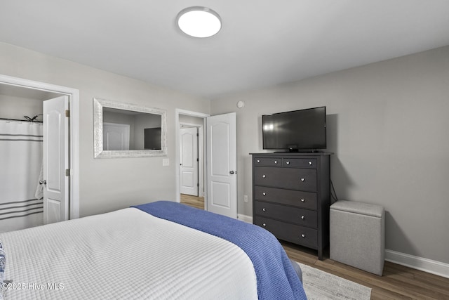 bedroom featuring wood finished floors and baseboards