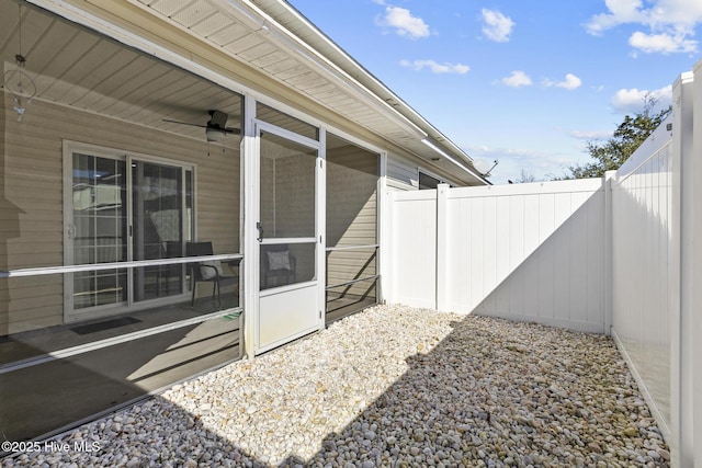 view of patio featuring a ceiling fan, a fenced backyard, and a sunroom