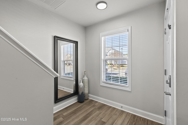 spare room featuring visible vents, baseboards, and wood finished floors