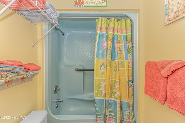 full bathroom featuring toilet and shower / bathtub combination with curtain