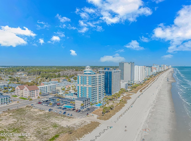 birds eye view of property with a water view, a view of city, and a beach view