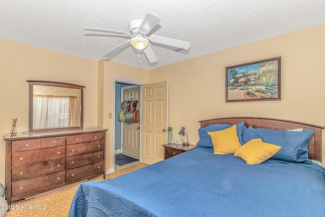 bedroom featuring baseboards, ceiling fan, a textured ceiling, and carpet