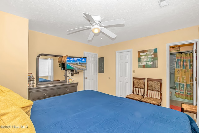 bedroom featuring electric panel, visible vents, a textured ceiling, and a ceiling fan