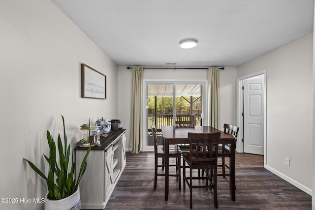 dining area with dark wood-type flooring and baseboards