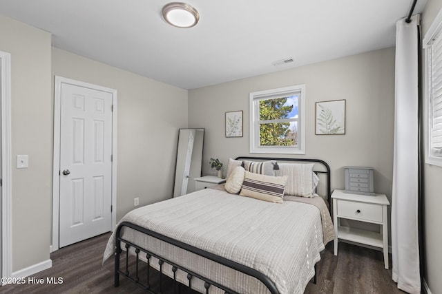 bedroom featuring visible vents, baseboards, and wood finished floors