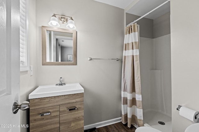 bathroom featuring vanity, wood finished floors, baseboards, curtained shower, and toilet