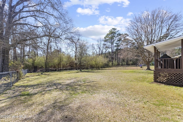 view of yard featuring fence and a sunroom