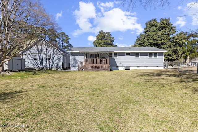 rear view of house with fence, a shed, a yard, central AC, and an outdoor structure