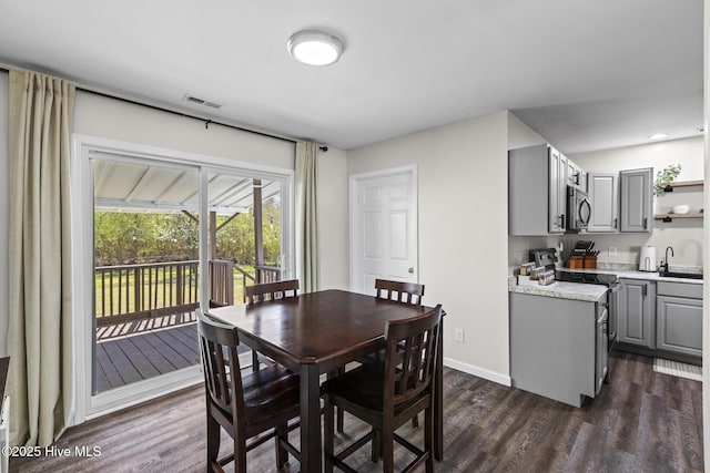 dining room featuring dark wood-type flooring, baseboards, and visible vents