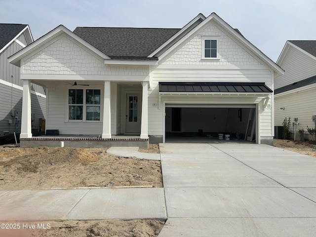 view of front of house featuring driveway, a standing seam roof, a porch, a garage, and metal roof