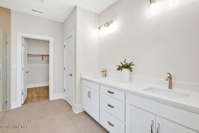 1340 Trisail Ter, Wilmington, NC 28412 - full bath featuring double vanity, a spacious closet, a tile shower, baseboards, and tile patterned flooring