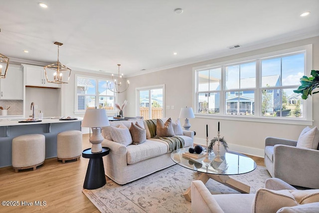 1340 Trisail Ter, Wilmington, NC 28412 - living room with a chandelier, light wood-type flooring, ornamental molding, recessed lighting, and baseboards