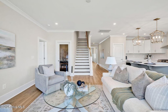 1340 Trisail Ter, Wilmington, NC 28412 - living room with light wood-style flooring, ornamental molding, baseboards, a chandelier, and stairway