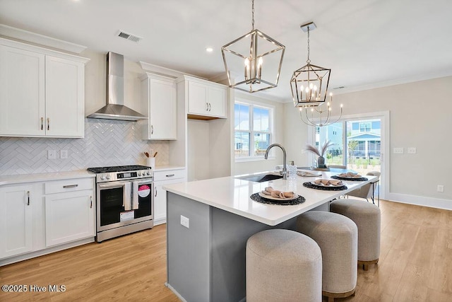 1340 Trisail Ter, Wilmington, NC 28412 - kitchen featuring gas range, wall chimney range hood, a sink, a chandelier, and white cabinets