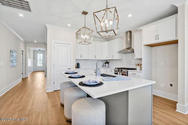 1340 Trisail Ter, Wilmington, NC 28412 - kitchen featuring wall chimney range hood, stainless steel range, a sink, a chandelier, and crown molding