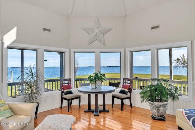 sunroom / solarium featuring visible vents and a water view