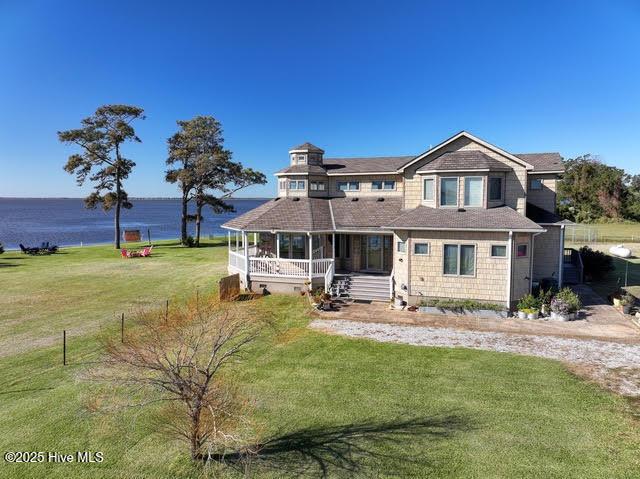 view of front of house with a water view, a porch, and a front lawn