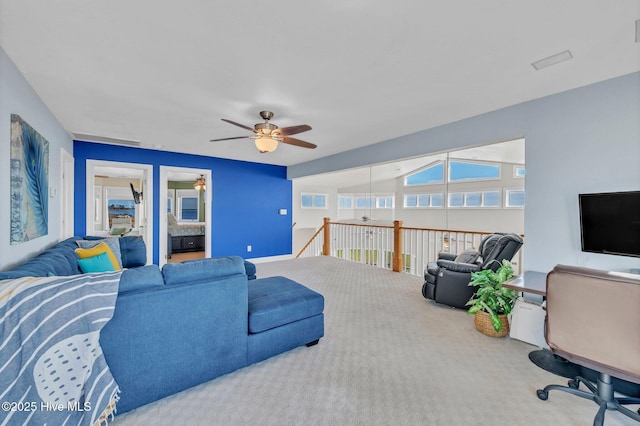 carpeted living area with baseboards, a ceiling fan, and vaulted ceiling