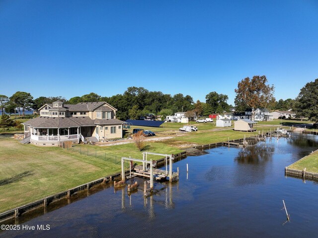 view of dock featuring fence, a yard, and a water view