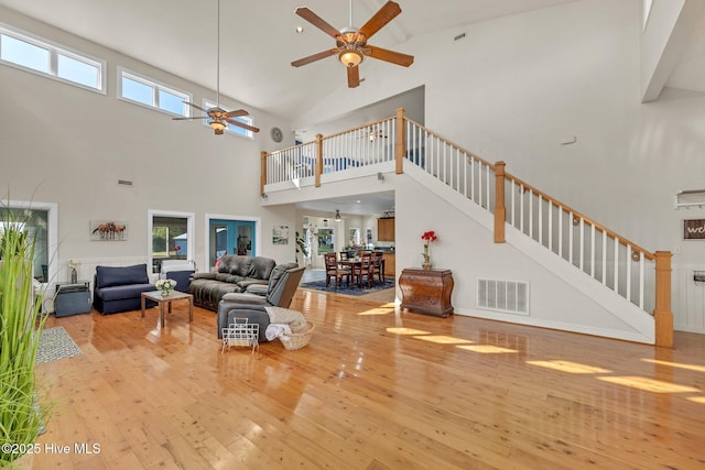 living room featuring hardwood / wood-style flooring, stairway, a healthy amount of sunlight, and visible vents