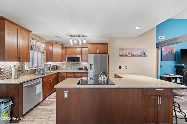 kitchen featuring a sink, decorative backsplash, a breakfast bar area, and stainless steel appliances