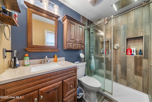 full bath featuring toilet, a stall shower, and vanity