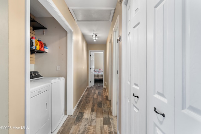 hall with dark wood-type flooring, baseboards, and washing machine and clothes dryer