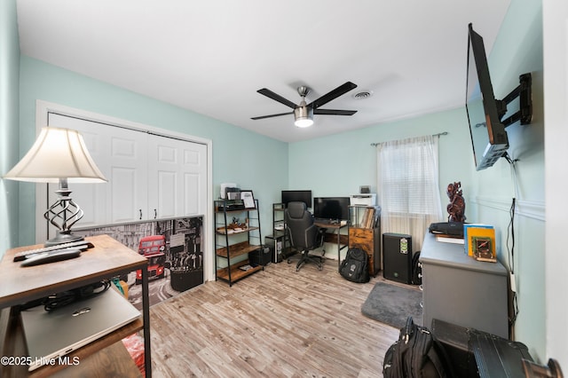 office area featuring light wood-type flooring, visible vents, and ceiling fan