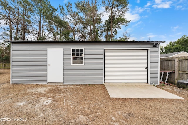 detached garage featuring fence