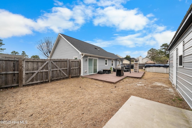 back of property featuring a deck and a fenced backyard