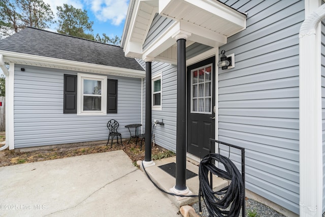 doorway to property featuring a shingled roof