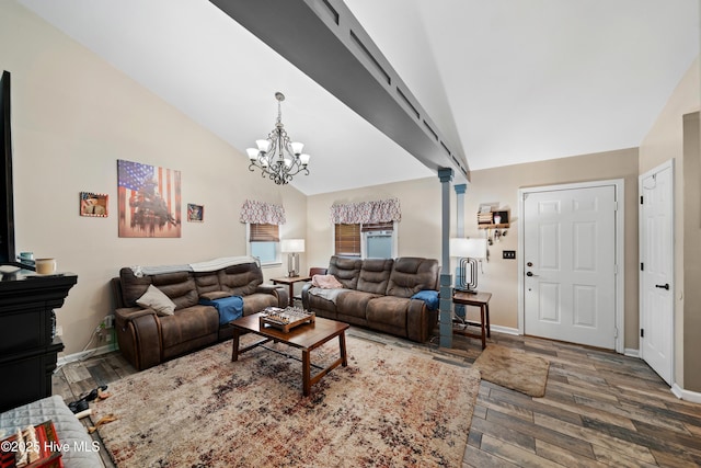 living room featuring a chandelier, baseboards, wood finished floors, and vaulted ceiling