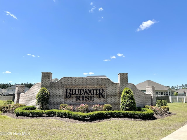 community sign featuring a yard and fence