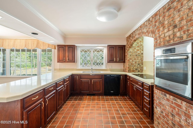 kitchen featuring black appliances, a peninsula, brick wall, and light countertops