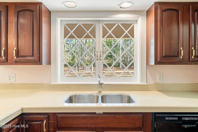 kitchen with a sink, dishwasher, and light countertops