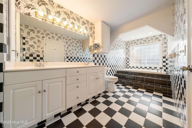 full bath featuring tile patterned floors, a sink, wallpapered walls, double vanity, and a bathtub