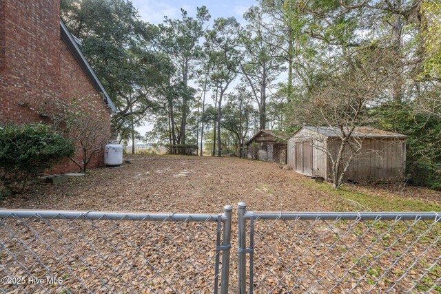 view of yard with a storage shed, an outdoor structure, and fence